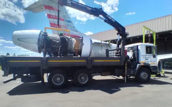 Picture of a airplane engine being loaded onto the HIAB truck