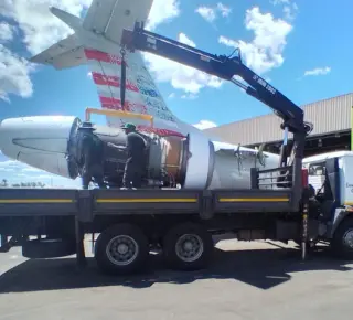 Picture of a airplane engine being loaded onto the HIAB truck