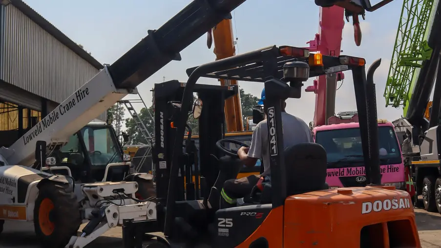 Picture of a forklift and bobcat parked next to each other