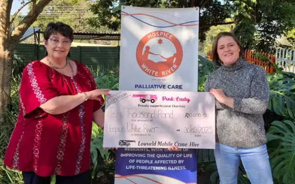 A representative of LMCH holding a donation board with a member of the White River Hospice