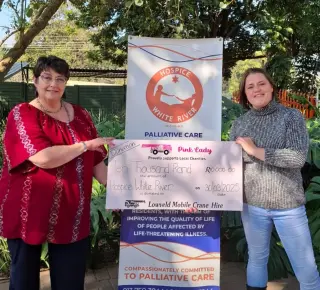 A representative of LMCH holding a donation board with a member of the White River Hospice